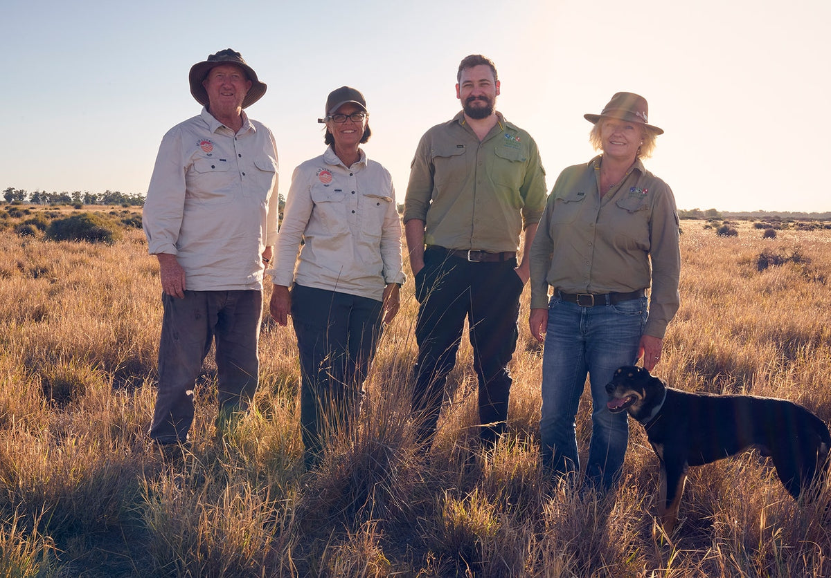 Jo Bear, Greg Bear and Trust for Nature representatives standing in grassland on the farm